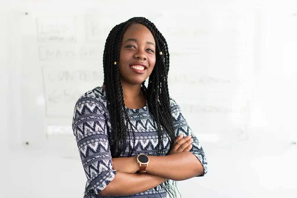 smiling teacher standing in front of a white board