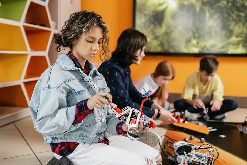 A group of young teenagers experimenting with Lego Technic